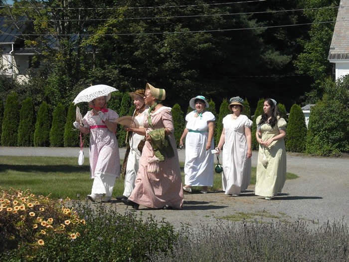 ladies walking in flower garden at Jane Austen in-character weekend