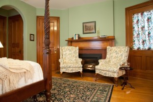 two wing chairs in front of burning fireplace in the Engish room
