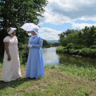 two ladies in Regency costume beside the river